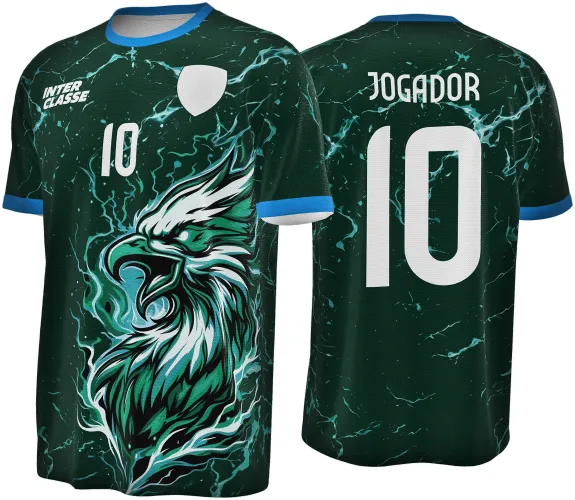 Camisa com estampa frontal de águia verde água iluminada por raios azuis com fundo verde escuro. Nas costas, número 10 e nome JOGADOR em branco. Gola e punhos azuis destacam o design vibrante.