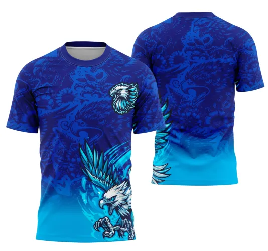 Camisa com grande águia branca e azul em voo, garras abertas, sobre fundo azul escuro com detalhes florais e indígenas. Frente com escudo da águia no peito; costas com ornamentos sombreados em azul e degradê azul ciano na parte inferior.