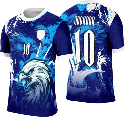 Camisa com frente azul, detalhe principal de uma águia branca e azul, texto Soccer e número 10 em branco. Costas azuis com nome JOGADOR e número 10 na mesma cor, fundo com efeito de pinceladas brancas e degradê azul, gola e punhos brancos.