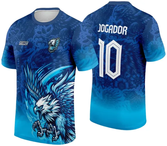 Camisa azul com águia branca e azul voando na frente, escudo pequeno de águia e texto 'SOCCER'; atrás o número 10 e palavra 'JOGADOR' brancos, sobre fundo com detalhes florais e imagens de águias em azul escuro.