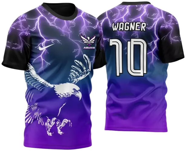 Camisa com frente mostrando águia branca com asas abertas sobre fundo em degradê azul para roxo e raios violetas, logo ÁGUIAS e Nike, costas com nome WAGNER e número 10 em branco sobre fundo com raios e degradê igual.