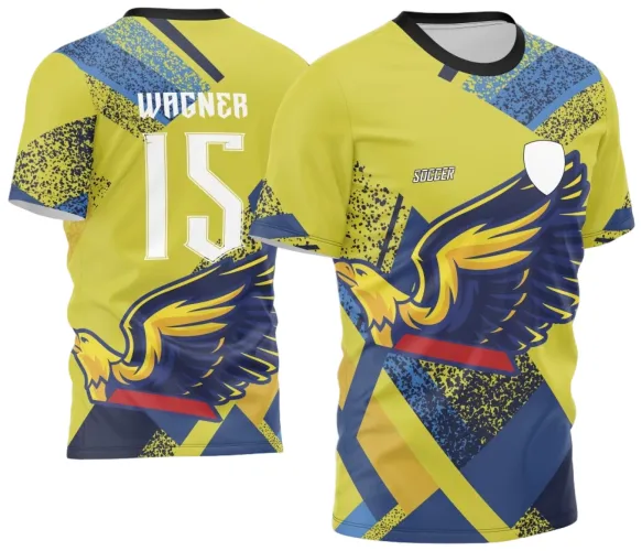 Camisa com fundo amarelo, destaque para grande águia azul e amarela na frente, textos SOCCER e escudo vazio, costas com nome WAGNER, número 15 em branco, padrão geométrico azul e amarelo e gola preta.