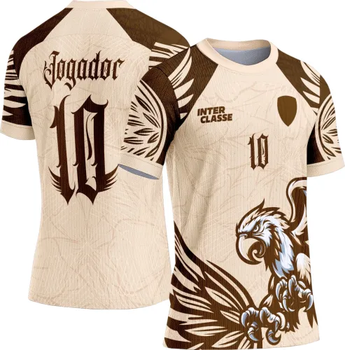 Camisa esportiva bege com águia marrom e branca na frente, texto INTER CLASSE e número 10 marrom, costas com o número 10 e palavra Jogador em fonte gótica, detalhes em penas marrons nas mangas e gola bege.