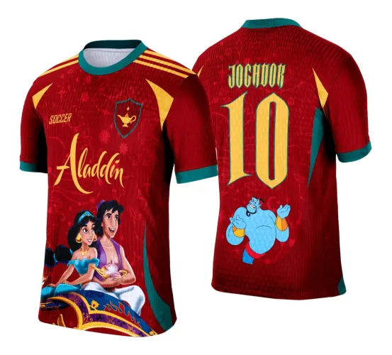 Camisa vermelha com detalhes verdes e amarelos, frente com Aladdin e Jasmine no tapete mágico e texto Aladdin, costas com número 10 amarelo, nome JOGADOR e figura do Gênio azul sorridente.