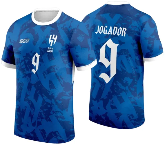 Camisa azul com estampa abstrata na frente com número 9 branco, logo Alhilal e texto Soccer, gola e mangas brancas. Nas costas número 9 grande e texto 'JOGADOR' em branco com fonte gótica.