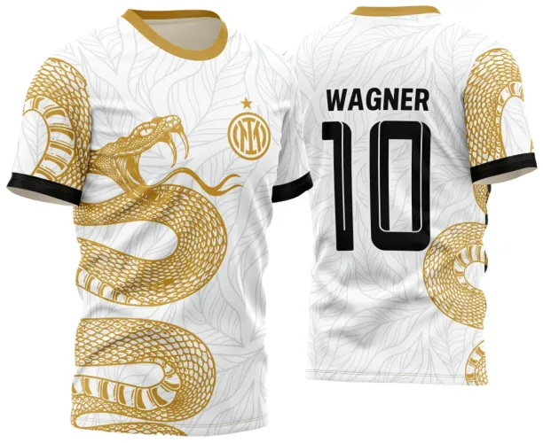 Camisa branca com estampa de cobra dourada com boca aberta na frente e fundo de folhas cinza, gola amarela e punhos pretos. Nas costas, nome WAGNER e número 10 em preto com detalhe da cauda da cobra dourada.