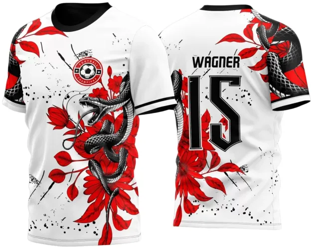 Camisa branca com cobra preta enrolada em flores e folhas vermelhas na frente, escudo redondo com bola e texto FOOTBALL CHAMPIONS, costas com nome WÁGNER e número 15 em preto, detalhes em splatter e mangas com faixa preta.