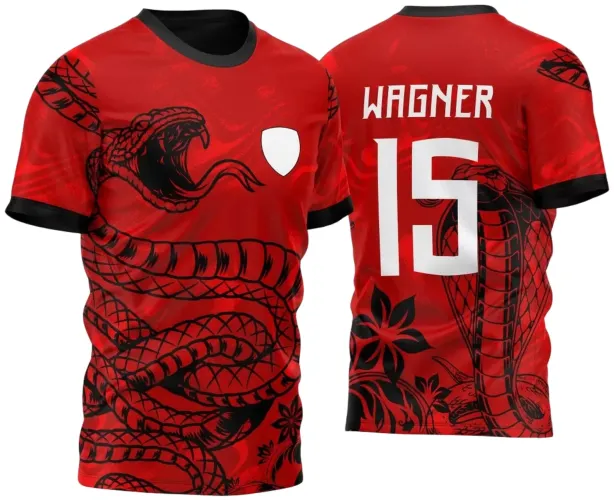 Camisa vermelha com estampa tribal de cobra preta na frente envolvendo o corpo, escudo branco do lado esquerdo do peito, costas com nome WAGNER e número 15 em branco, detalhes florais e barras pretas nas mangas.