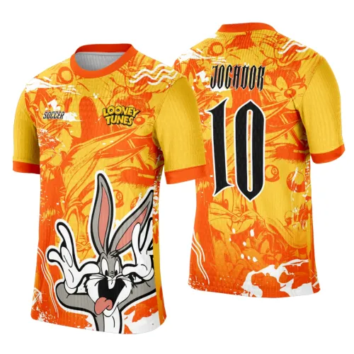 Camisa com fundo degradê laranja e amarelo, grande ilustração do Coelho Pernalonga frontal, textos LOONEY TUNES e SOCCER; costas com número 10 preto e JOGADOR, gola e punhos em laranja vibrante