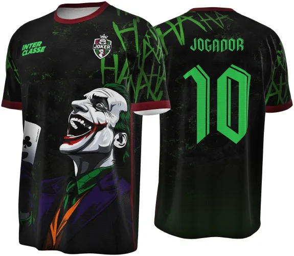 Camisa preta com ilustração do Coringa rindo e segurando carta na frente, detalhes em verde, bordô na gola e mangas, nas costas texto 'JOGADOR' e número 10 em verde, fundo com padrão repetido 'HA HA HA'.