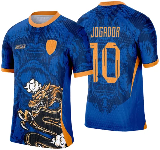 Camisa azul com gola e punhos laranja, dragão estilizado em laranja e preto na frente com fumaça branca, escudo laranja no peito, texto SOCCER, nas costas nome JOGADOR e número 10 em laranja sobre fundo com dragão sombreado.