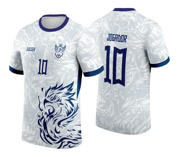 Camisa branca com estampa tribal de fênix azul-marinho na frente, gola e punhos em azul. Nas costas, nome 'JOGADOR' e número 10 em azul, com padrão abstrato de fênix ao fundo em tons claros.