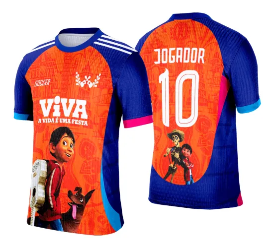 Camisa com frente laranja mostrando menino com violão e cachorro, fundo azul nas mangas, texto 'SOCCER' e 'VIVA A VIDA É UMA FESTA'. Costas laranja com 'JOGADOR' e número 10, além de mascote esqueleto com menino. Mangas azuis com detalhes rosa e azul claro.