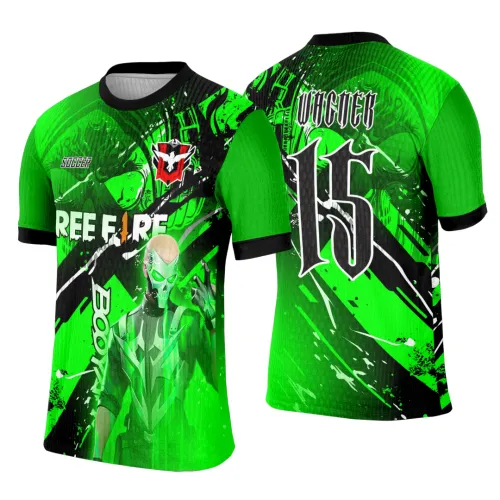 Camisa verde com mangas lisas e punhos pretos, frente mostra personagem mascarado em verde e preto com texto FREE FIRE e BOOYAH!, costas com grande número 15 e texto SOCCER em fonte gótica, fundo com detalhes gráficos abstratos.