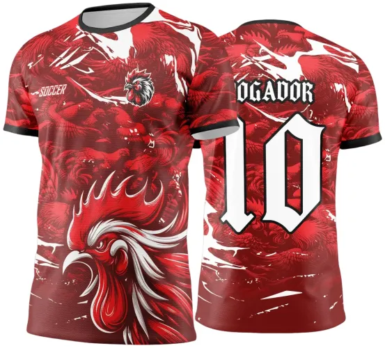 Camisa vermelha com estampa grande de galo na frente, mascote pequeno no peito e texto 'SOCCER'. Costas exibem número 10 em branco e texto 'JOGADOR' em fonte gótica, mangas e gola com detalhes pretos.