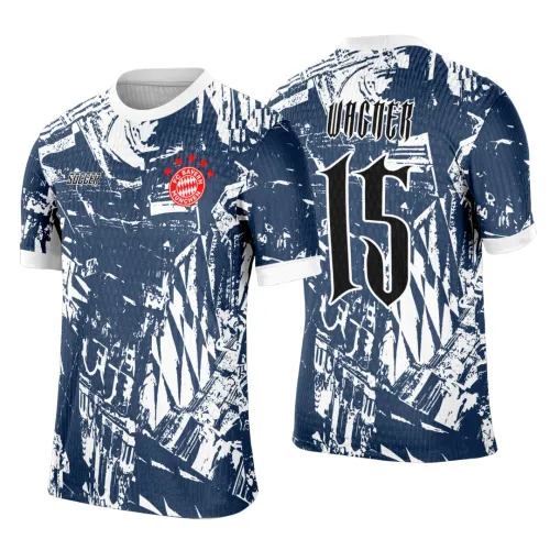 Camisa azul e branca com detalhes gráficos abstratos, escudo vermelho FC BAYERN MUNCHEN na frente, texto SOCCER ao lado; costas exibem nome WAGNER acima do número 15 em preto com contorno branco. Golinha e punhos brancos.
