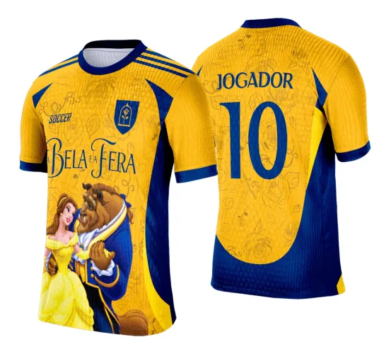 Camisa amarela e azul com estampa frontal de Bela e a Fera abraçados, textos SOCCER e BEL A e A FERA, escudo com rosa no peito. Nas costas nome JOGADOR e número 10 em azul, fundo floral.