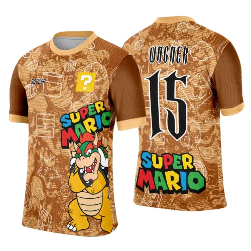 Camisa marrom com Bowser na frente, degradê e detalhes de moedas e blocos; costas com nome WAGNER, número 15 e texto SUPER MARIO colorido, mangas marrons com punhos amarelos e fundo com ícones do jogo em contorno branco.