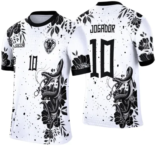 Camisa branca com gola e punhos pretos, ilustrada com cobra preta entre flores pretas na frente e costas. Frente tem número 10, escudo de cobra e texto SOCCER. Costas mostram o número 10 grande e a palavra JOGADOR acima.