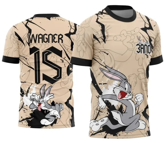 Camisa bege com linhas pretas possui um coelho cinza correndo animado na frente com o texto 3ANO no peito e, nas costas, o mesmo coelho com expressão engraçada, nome WAGNER e número 15 em preto destacam-se.
