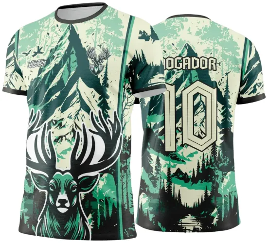 Camisa com estampa frontal de um cervo verde com chifres destacados, montanhas e floresta em tons de verde, creme e preto. Costas exibem o número 10 em creme com texto JOGADOR acima, mantendo fundo de montanhas e árvores.