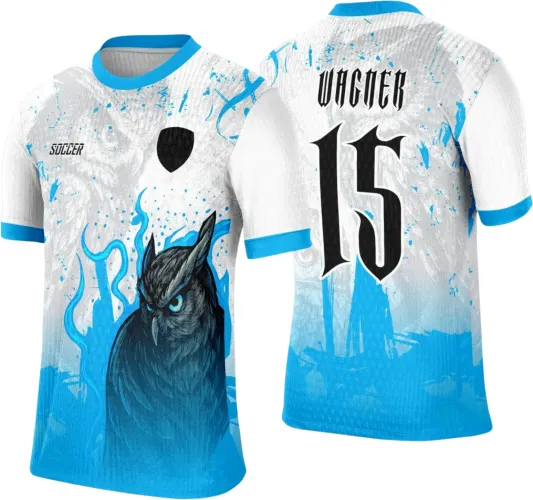 Camisa branca com gola e punhos azuis, frente com coruja preta e olhos azuis destacados, logo Soccer e escudo preto, costas com nome Wagner e número 15 em preto com contorno branco, fundo com degradê azul e grafismos sutis.