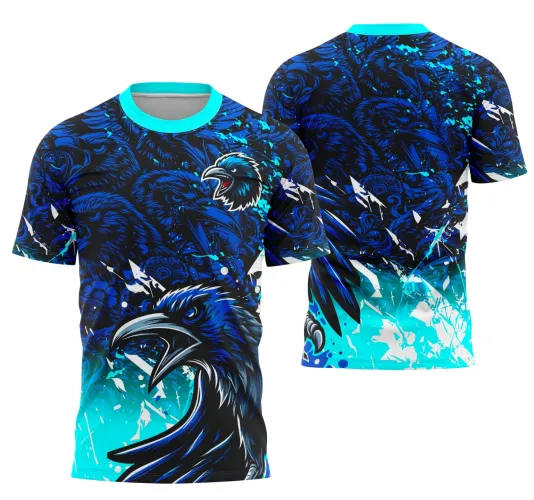Camisa azul com degradê que vai do azul elétrico ao preto, mostrando na frente um corvo poderoso com o bico aberto, nas costas vários rostos de corvo em azul escuro e detalhes gráficos dinâmicos. Gola azul clara completa o visual.