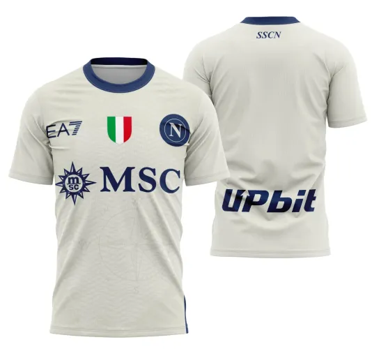 Camisa branca com gola azul marinho, frente com escudo azul com N, faixas verde, branca e vermelha, logos MSC e EA7 azuis, fundo com bússola sutil. Costas com texto SSCN acima e logo Upbit azul na parte inferior.