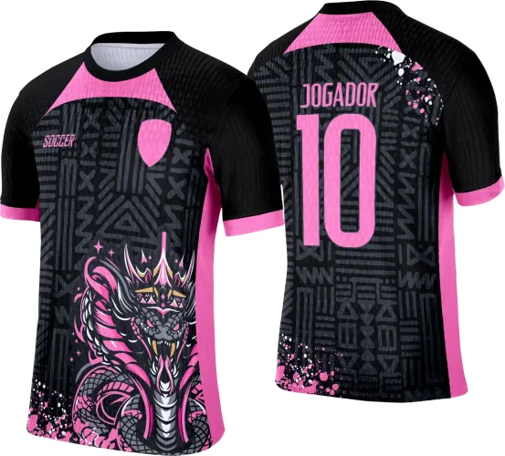 Camisa preta com estampas geométricas em cinza, figura frontal de cobra rosa e preta coroada, detalhes rosas nas mangas e laterais, texto SOCCER no peito e JOGADOR 10 nas costas com respingos decorativos rosas e brancos.