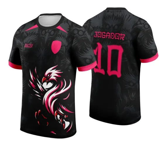 Camisa preta com desenho grande de uma fênix branca e rosa na frente, escudo rosa e palavra SOCCER. Nas costas, o texto JOGADOR e número 10 em rosa, fundo com várias cabeças de fênix em preto escuro e detalhes rosa na gola e nas mangas.