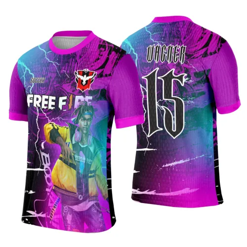 Camisa violeta com degradê rosa e azul, frente com personagem em jaqueta amarela, textos FREE FIRE, BOOYAH e SOCCER, logo vermelho e branco; costas com nome VICKER e número 15 em branco. Mangas e gola rosas com detalhes de raios azuis.