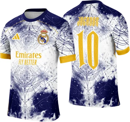 Camisa com frente branca e azul escuro em degradê e estampa geométrica de galáxia, detalhes amarelos nas mangas e textos 'Emirates FLY BETTER' e escudo do Real Madrid à frente. Nas costas, número 10 e 'JOGADOR' em amarelo.