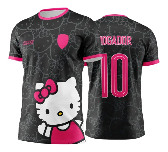 Camisa preta com estampas em tons de cinza da Hello Kitty em todo o corpo, gola e mangas com acabamento rosa, frente exibe grande figura da Hello Kitty com vestido rosa, costas com texto JOGADOR e número 10 em rosa vibrante.