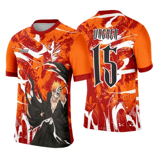 Camisa laranja com estampa de Ichigo em pose de ataque e máscara hollow na frente, textos SOCCER no peito; costas com nome VAGNER, número 15 grande em preto, fundo com grafismos em laranja, branco e vermelho.