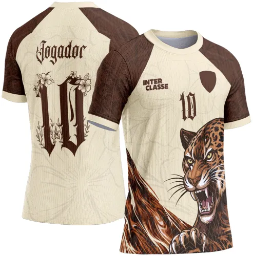 Camisa com estampa de onça pintada frontal agressiva em cores creme e marrom, mangas e gola marrons. Verso com número 10 e palavra Jogador em fonte gótica com detalhes florais e fundo texturizado em creme.