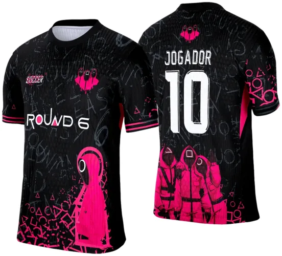 Camisa preta com figura frontal de personagem de capuz rosa, símbolos espalhados, texto ROUND 6 no peito e SQUIDER no ombro. Costas com três personagens de capuz rosa, número 10 grande e nome JOGADOR em branco, detalhes em rosa nas mangas.