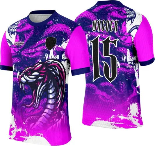 Camisa com serpente rosa e fundo azul escuro, texto 'SOCCER' na frente e escudo preto, costas exibem número 15 em preto com contorno branco e nome VAGNER acima, mangas rosa com detalhes azul escuro