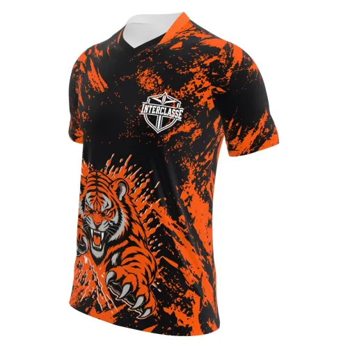 Camisa com estampa de tigre feroz na frente, fundo preto com manchas laranja vibrantes, detalhes modernos e nome personalizado nas costas, cobrindo toda a peça.