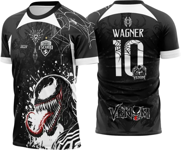 Camisa preta com detalhes brancos apresenta na frente o personagem Venom com língua vermelha e dentes marcantes, teias nas mangas e escudo 'SEU ESCUDO'. Nas costas, nome WAGNER, número 10 com teias e logo Venom, tudo em branco e vermelho.