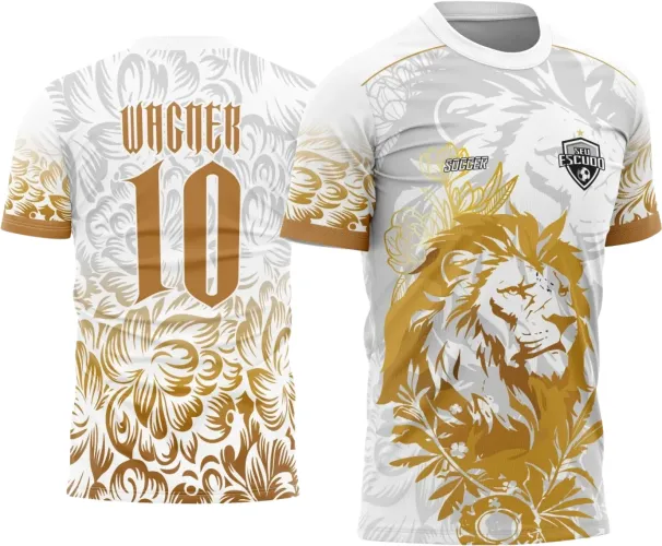 Camisa branca com estampa frontal de um leão dourado cercado por folhas, escudo 'SEU ESCUDO' preto e branco no peito, costas com nome WAGNER e número 10 em dourado, detalhes florais em dourado nas mangas e parte inferior.