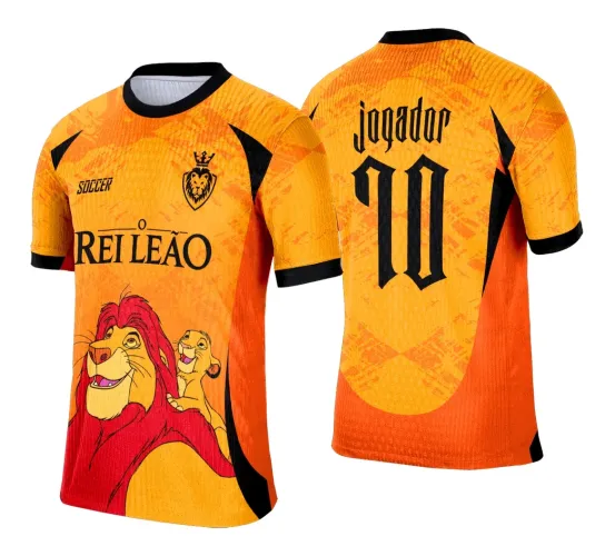 Camisa laranja com detalhes em preto e vermelho, frente mostra ilustração de leão e filhote com texto O REI LEÃO, costas exibem JOGADOR 10 em preto com degradê laranja-dourado