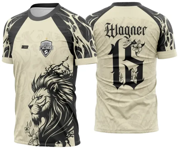 Camisa bege com manga preta e estampa frontal de leão em preto, escudo 'SEU ESCUDO' no peito e texto 'SOCCER'. Costas com nome Wagner e número 15 em fonte gótica preta decorados com flores.