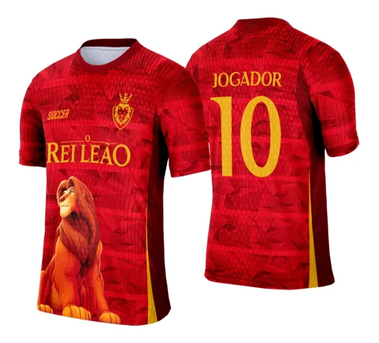 Camisa vermelha com figura realista de leão na frente, textos amarelos como O REI LEÃO e SOCCER e escudo com leão coroado; nas costas, JOGADOR e número 10 destacados em amarelo.