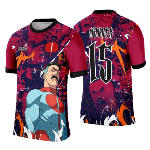 Camisa com super-herói de bigode em frente azul claro e vermelho, fundo vermelho e azul com detalhes laranja; costas com número 15 branco e nome VICNER em estilo gótico, mangas vermelhas com punho preto.