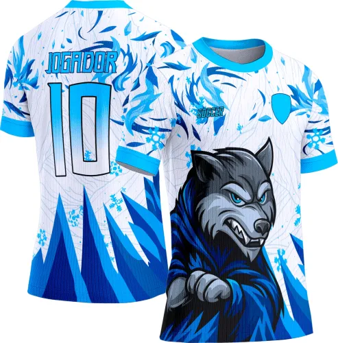 Camisa com estampa frontal de lobo azul com detalhes cinza em pose agressiva, fundo branco com ornamentos azuis, escudo azul no peito e texto 'SOCCER'. Nas costas número 10 em degradê azul com borda preta e palavra 'JOGADOR' acima.