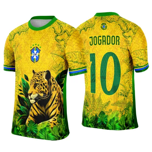 Camisa amarela com colarinho verde e laterais verdes, frente com onça deitada entre folhas verdes e escudo azul CBF, costas com o texto JOGADOR e número 10 em verde sobre fundo amarelo com folhas estilizadas