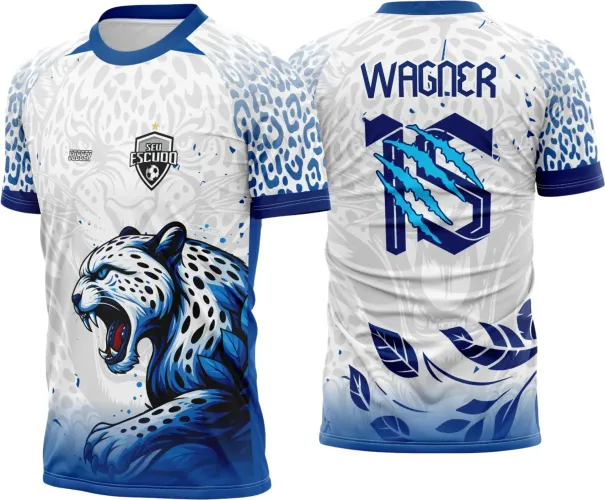 Camisa branca com detalhes em azul, onça estilizada agressiva na frente e nome WAGNER com número 10 riscado em azul nas costas, mangas com estampas de onça, gola e punhos em azul escuro, fundo branco com padrão leve de onça.