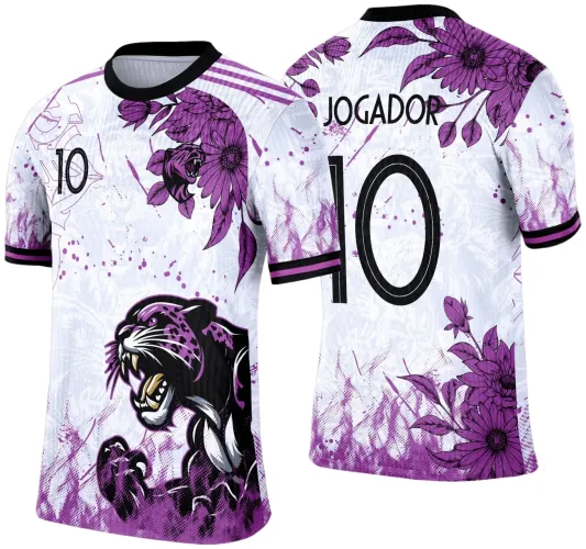 Camisa branca com figura central de onça preta e roxa na frente, adornada com flores roxas no ombro e detalhes em degradê roxo. Nas costas, o texto 'JOGADOR' acima do número 10 preto, com flores roxas nos ombros e na parte inferior.