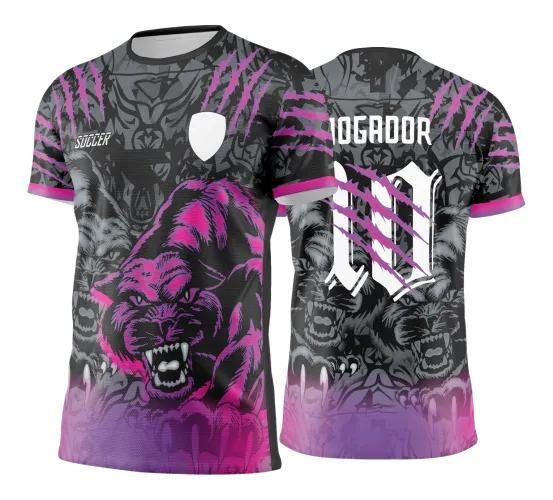 Camisa esportiva com estampa frontal de pantera rosa feroz sobre fundo cinza com garras em rosa, escudo branco vazio e texto 'SOCCER'. Nas costas, nome 'JOGADOR' e número 10 branco, com detalhes de panteras cinza e degrade rosa na base.