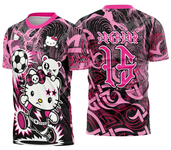 Camisa com arte punk em rosa e preto, frente mostra personagem estilo Hello Kitty chutando bola de futebol e detalhe pequeno no peito; costas têm número 14 em rosa e texto JOGADOR sobre fundo com grafismos abstratos.